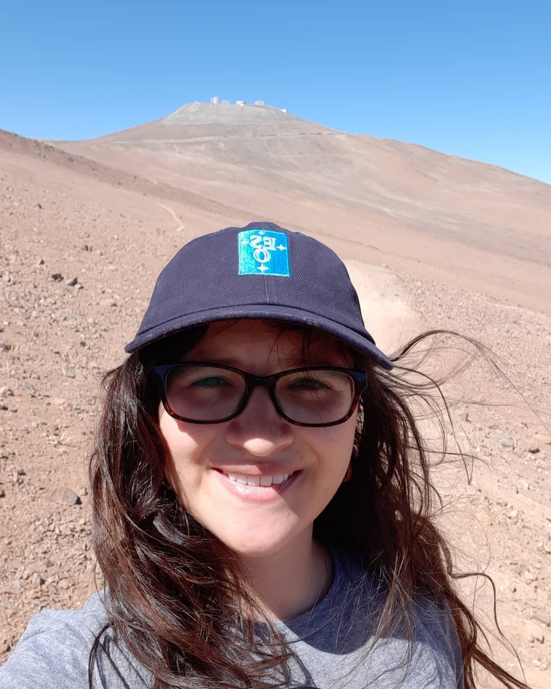A photo of me and in the background are The Very Large Telescope at Paranal in Chile.