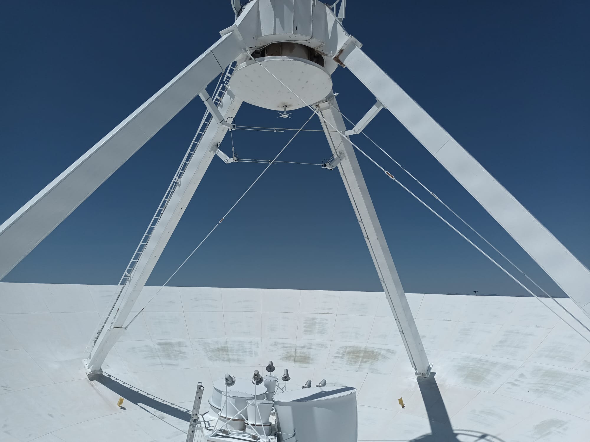 Photo on top of the VLA showing the
											reciver bands on top of the primary dish, and the subreflector on top