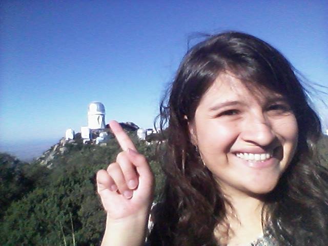 Sofía pointing at the  Mayall 4-m Telescope
													from the opposite mountain at the Kitt Peak Observatory